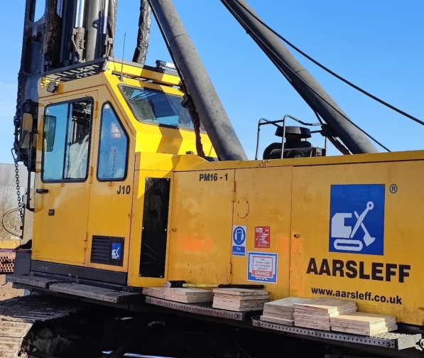 Aarsleff's Yellow Junttan PM16-1 Piling Rig Under A Clear, Blue Sky.