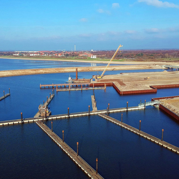 Aerial view of marine works of a new harbour with long walkways extending into the water
