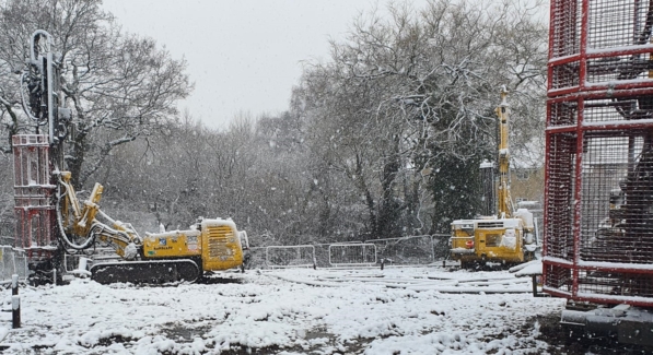 Yellow Drilling Rigs Sitting On A Snowy Construction Site.