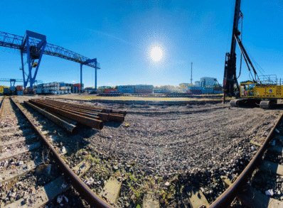 Railway tracks and an Aarsleff yellow piling pig under a blue sky