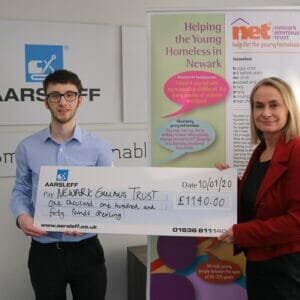 Aarsleff's Marketing Assistant Harrison presenting Newark Emmaus Trust CEO Nikki Burley with a cheque.