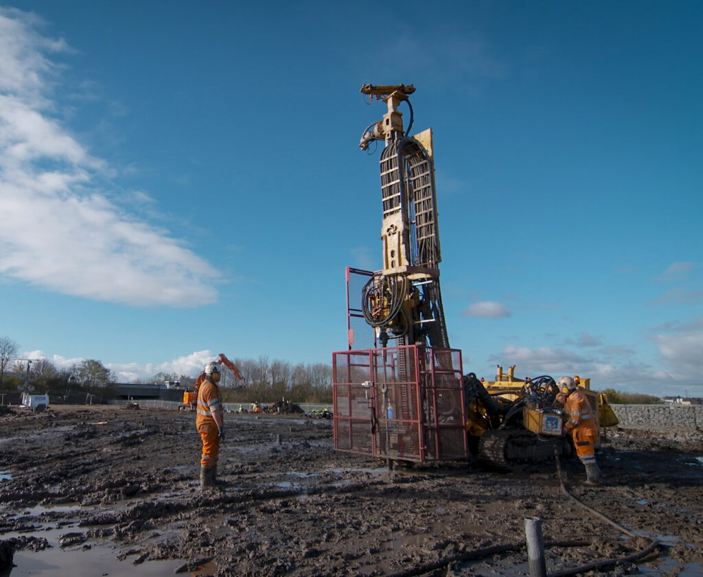 Two professionals overseeing soil stabilization during drilling and grouting operations, demonstrating expertise in the drilling and grouting technique for soil engineering in the field of civil engineering.